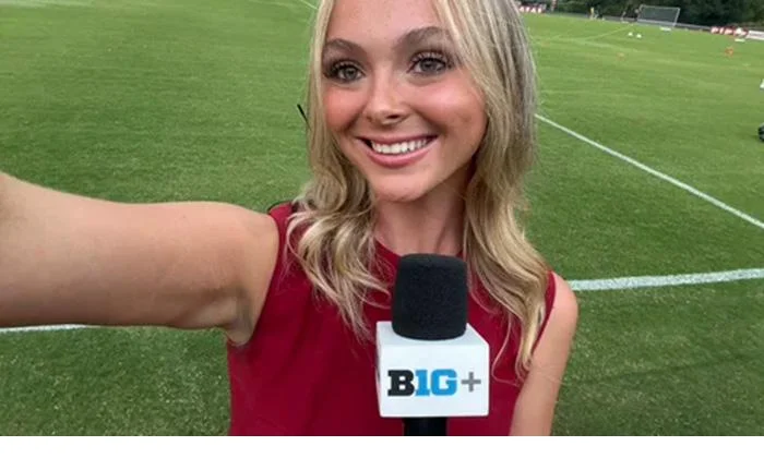 Josie sideline reporting with Big Ten Plus microphone